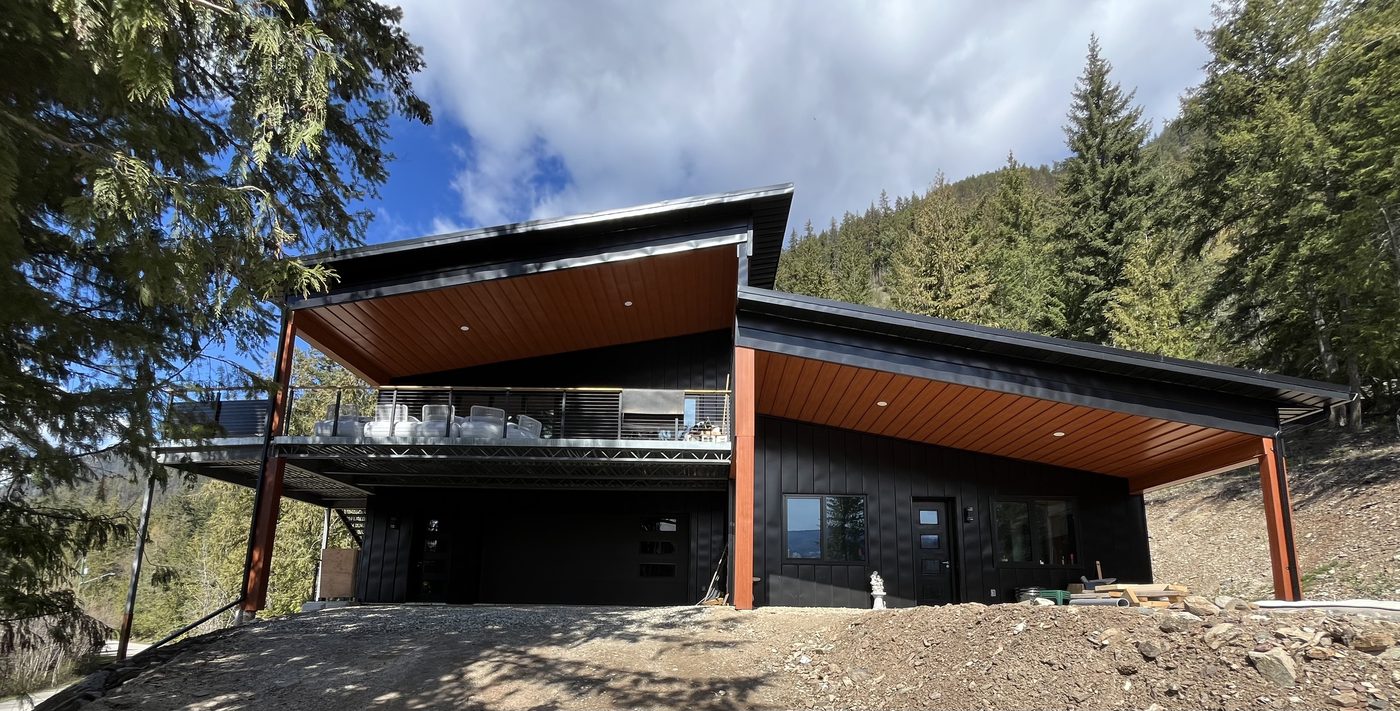 Modern custom home with wood siding and covered deck