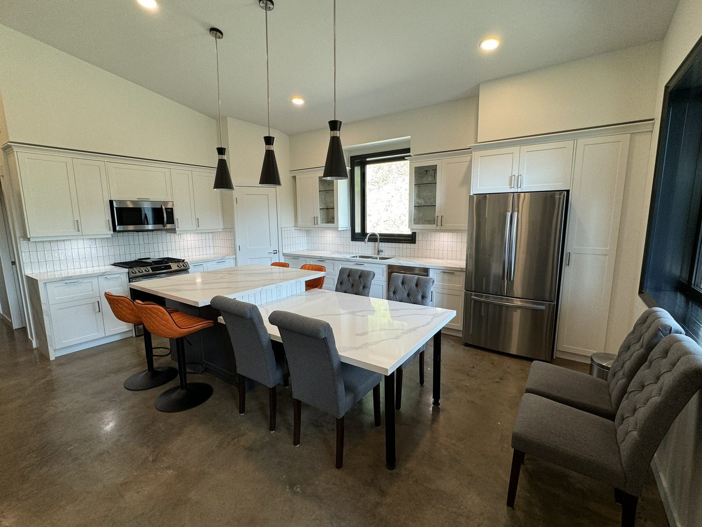 Custom kitchen with waterfall quartz island and pendant lighting